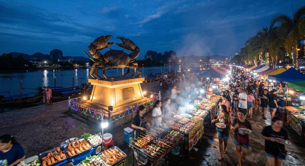 Krabi Town riverside, with the giant crab statue and the night market Krabi Town riverside, with the giant crab statue and the night market